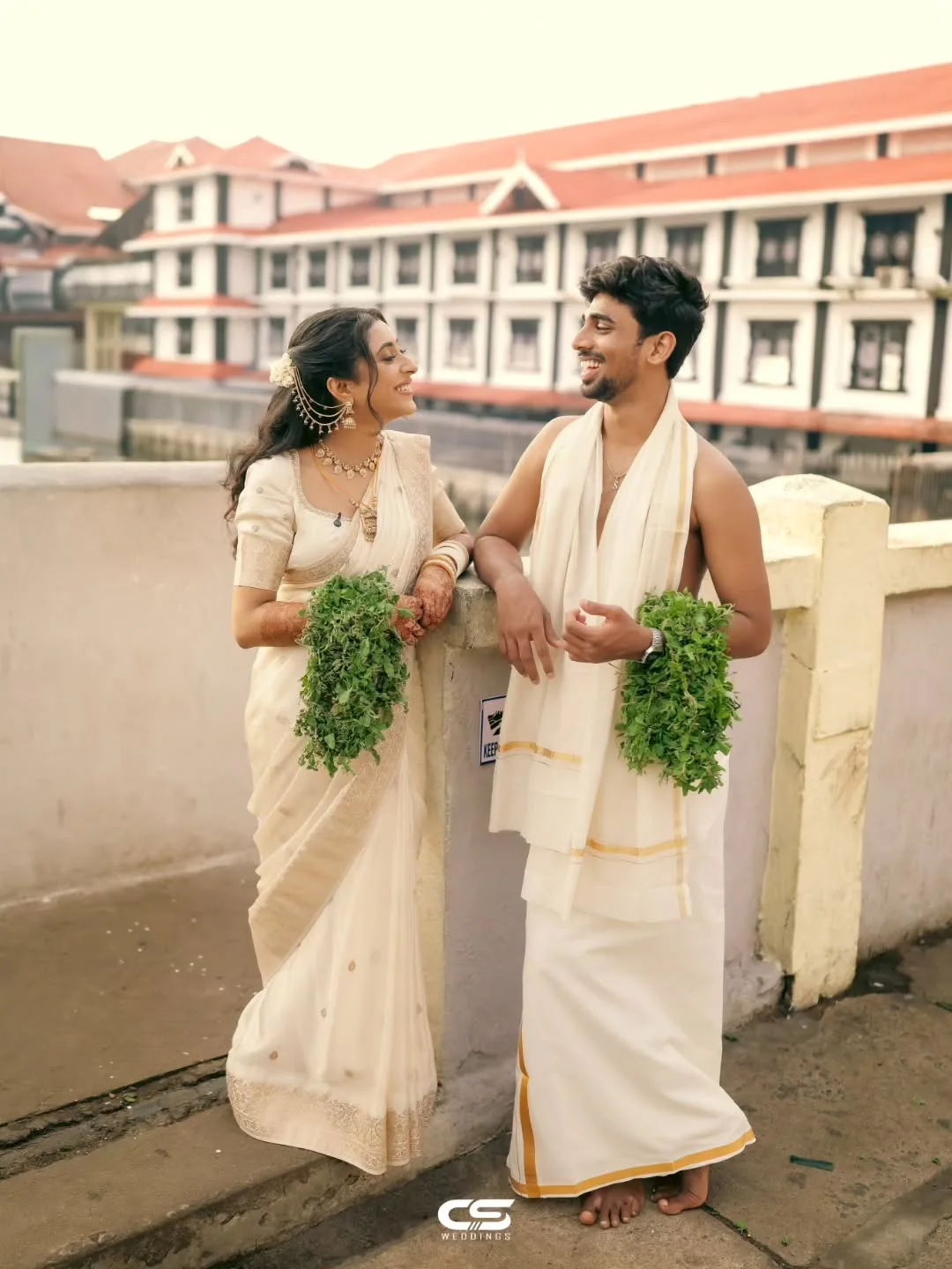 Newlyweds sharing a laugh in traditional Kerala wedding attire